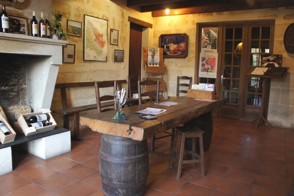 La salle de dégustation de la Prami, avec sa cheminée et sa table sur tonneau